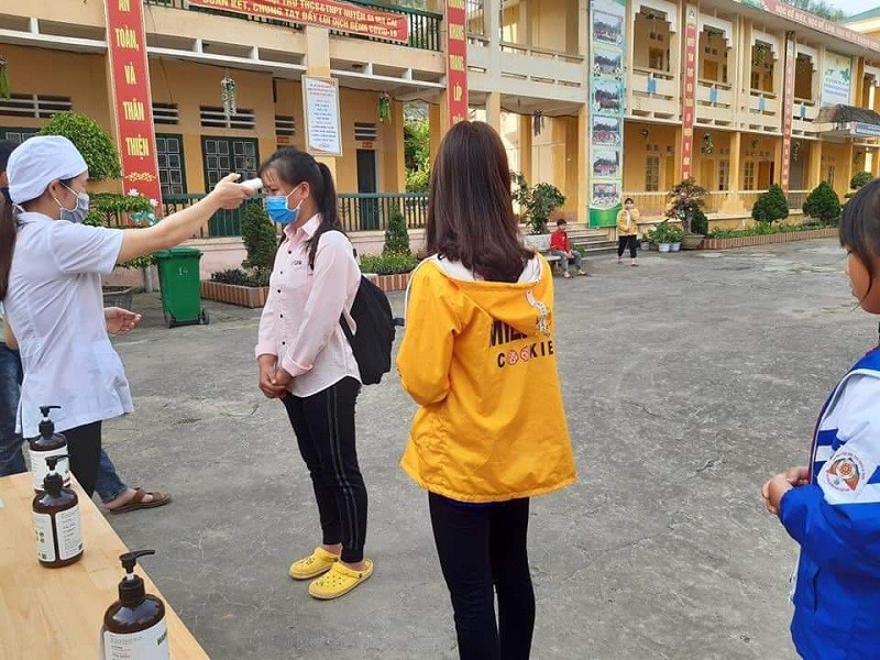 Đo thân nhiệt và khử khuẩn tay trước khi vào lớp tại Trường PTDTNT THCS & THPT huyện Si Mai Cai (Lào Cai) sáng 4/5. Ảnh: NTCC