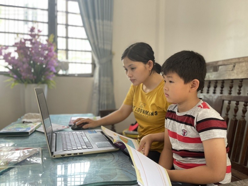 Phụ huynh tại TP Hà Tĩnh hướng dẫn con học ôn trực tuyến. Ảnh: Phượng Vũ