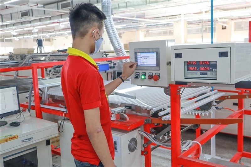 Một công nhân kỹ thuật cao đang vận hành máy tại một đơn vị sản xuất trong KCN Quận 9, TPHCM.