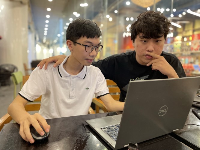 Dương Tiểu Đồng (bên trái) học hỏi kinh nghiệm, kỹ năng từ chuyên gia Phạm Tiến Mạnh. Ảnh: Lưu Quý