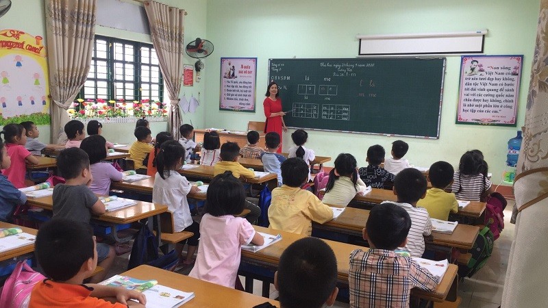 GV cần chủ động thích nghi với sự thay đổi và yêu cầu chung của SGK trong quá trình dạy học. (Trong ảnh: GV và HS lớp 1 Trường Tiểu học Pom Hán,
Lào Cai). Ảnh: NTCC