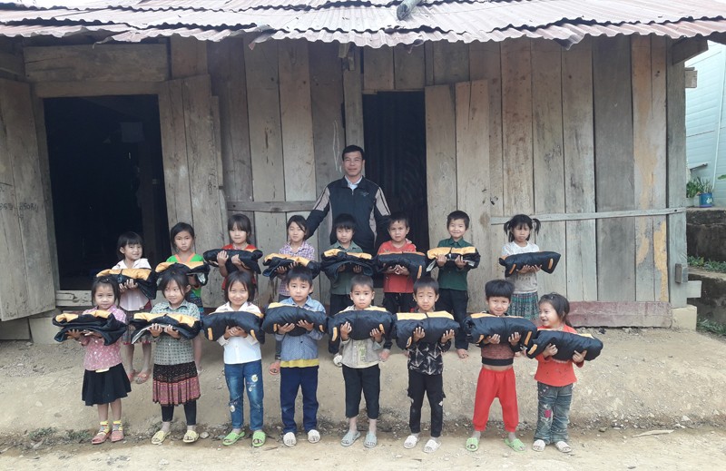 Thầy giáo Lò Văn Công và học sinh của mình tại điểm trường Huổi Hạ.