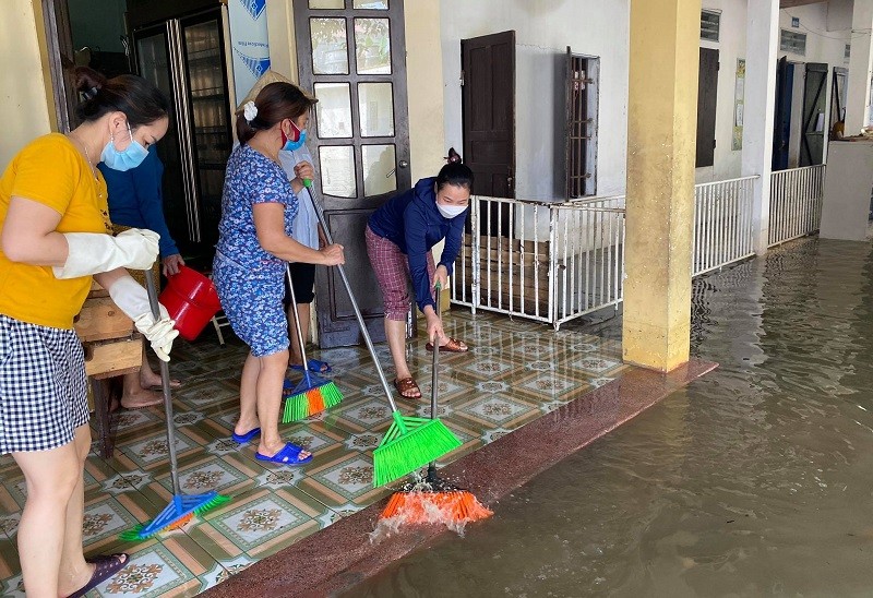 Giáo viên huyện Quỳnh Lưu dọn dẹp vệ sinh trường lớp khi nước bắt đầu rút.