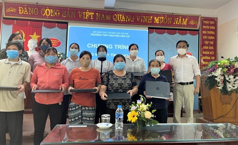 Thầy Nguyễn Minh Phi - Hiệu trưởng Trường THPT Nguyễn Văn Cừ trao laptop cho HS có hoàn cảnh khó khăn.