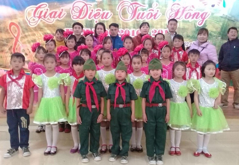 Cô Hoa và thầy Thái (thứ 3 và thứ 4 từ trái qua) chụp hình lưu niệm cùng các em học sinh.