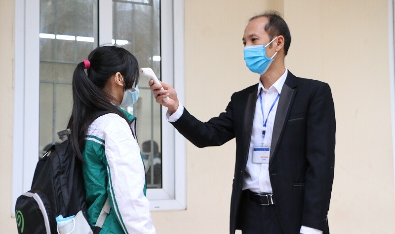 Các học sinh trường THCS ở huyện Ba Vì  được đo thân nhiệt, sát khuẩn tay trước khi vào lớp ngày 8/11. Ảnh: Đình Tuệ 