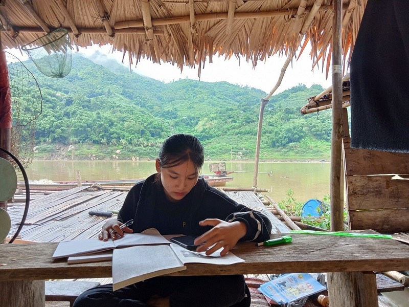 Em Ngân Thị Khanh, học sinh lớp 12, Trường THPT Mường Lát xuống bè cá của gia đình lòng hồ Thủy điện Trung Sơn (xã Trung Lý, Mường Lát, Thanh Hóa) hứng sóng để học trực tuyến.