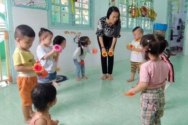 Cô Huỳnh Hồng Loan với các em học sinh mẫu giáo. 	Ảnh tư liệu