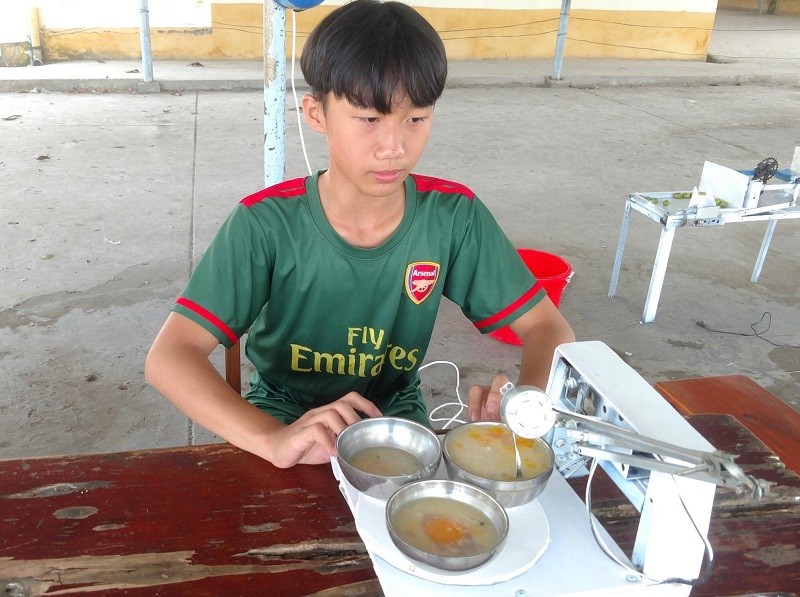 Trương Hoàng Phúc, học sinh lớp 8 Trường THCS Nguyễn Khuyến bên sáng chế robot giúp chọn món, múc và đút thức ăn.