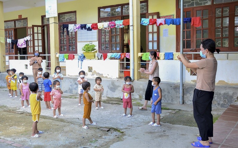 Cô giáo Trường Mầm non Mường Pồn (huyện Điện Biên) hướng dẫn học sinh tập thể dục và vệ sinh cá nhân trong khu cách ly.