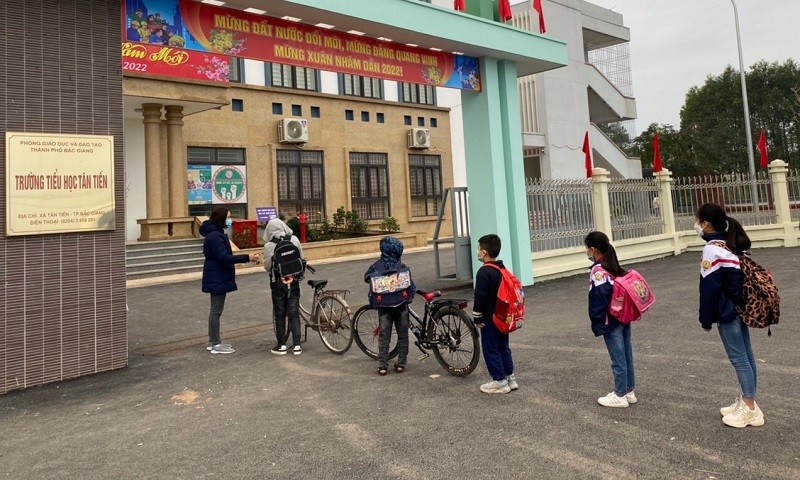Học sinh Trường Tiểu học Tân Tiến (thành phố Bắc Giang) xếp hàng đo thân nhiệt từ cổng trường.
