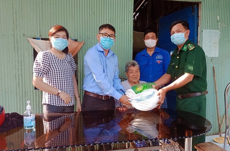 Cán bộ Đồn Biên phòng Phú Tân phối hợp với MTTQ Việt Nam xã Phú Tân tặng gạo và nhu yếu phẩm cho bà Nguyễn Thị Hành.