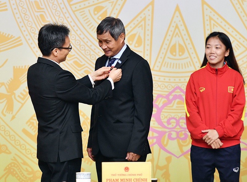Huấn luyện viên Mai Đức Chung (giữa) nhận Huân chương Lao động hạng Nhất.