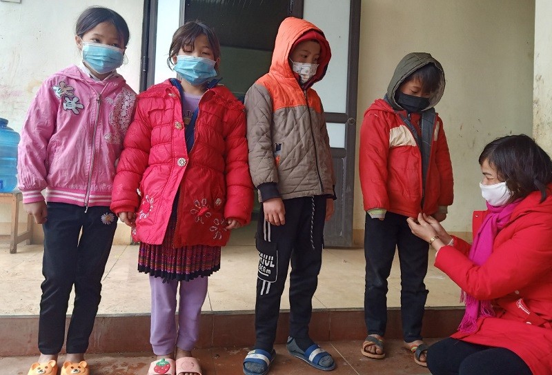 Cô Hoàng Thị Oánh tận tay mặc áo ấm cho học sinh.