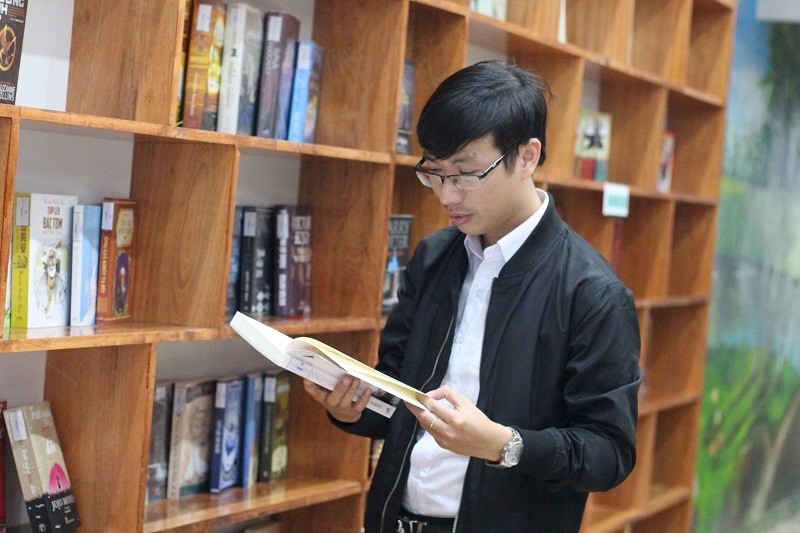 Thầy giáo Đặng Văn Mười bên thư viện mini Hiền Nhân. 