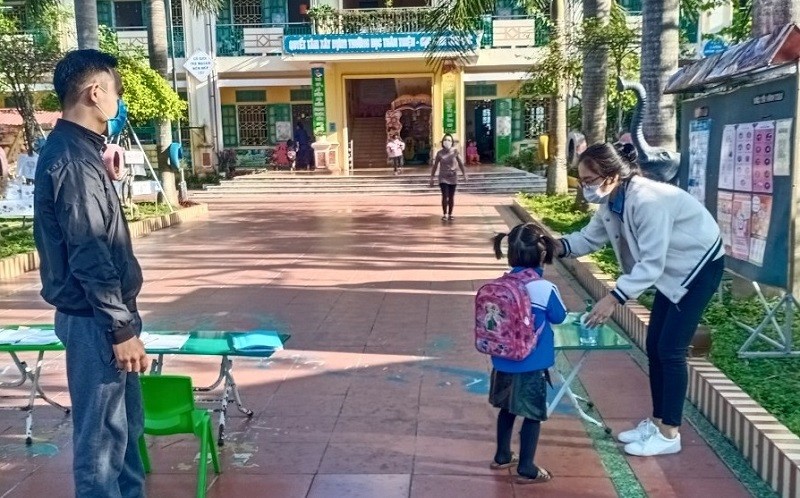 Đo thân nhiệt, phân luồng, giữ khoảng cách đón trẻ vào lớp tại Trường MN Hải Tân, huyện Hải Hậu, 
tỉnh Nam Định. Ảnh: TG