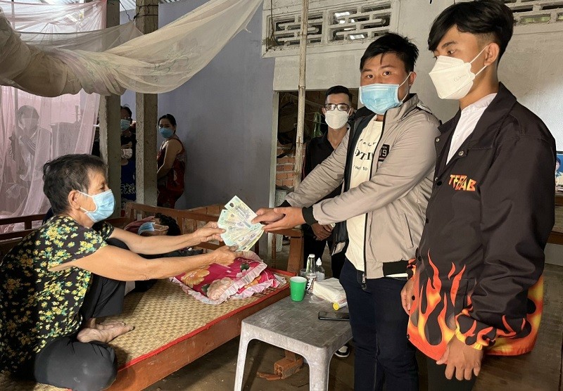 Minh Thuận (đứng giữa) trong hoạt động hỗ trợ người dân hoàn cảnh khó khăn.  