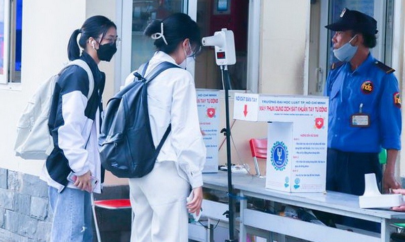Máy đo nhiệt độ và thiết bị khử khuẩn được đặt trước cổng Trường Đại học Luật TP Hồ Chí Minh luôn sẵn sàng kiểm tra, bảo vệ sức khỏe sinh viên. Ảnh: NTCC