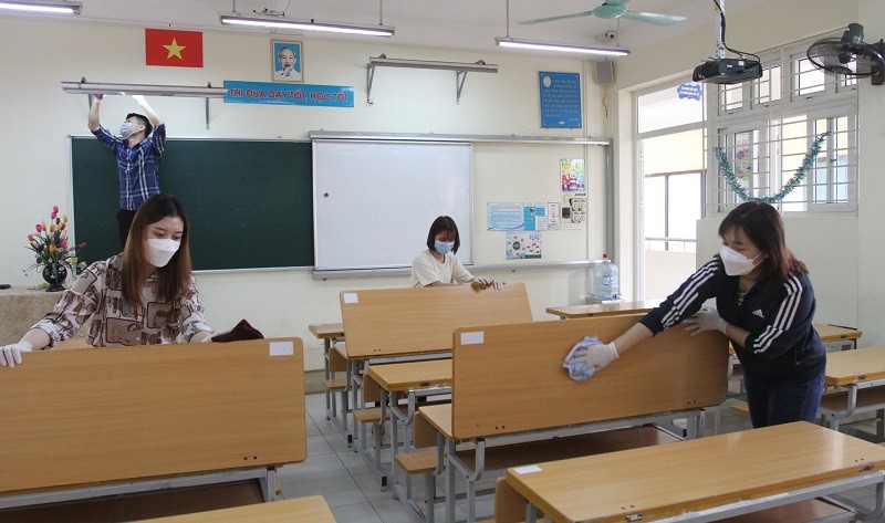 Các giáo viên vệ sinh khử khuẩn, sẵn sàng đón học sinh trở lại trường.