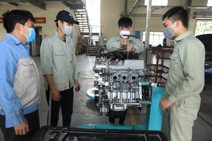 Học sinh một trường trung cấp trong giờ thực hành sửa chữa máy ô tô.