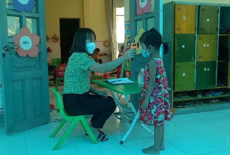 Giáo viên Trường Mầm non Nậm Chà kiểm tra sức khỏe cho trẻ.