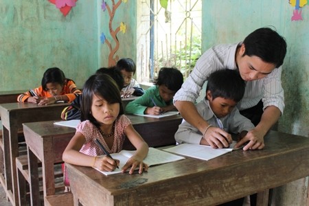 Thầy Trần Văn Hơn - giáo viên Trường PTDT Bán trú Tiểu học và THCS Phước Lộc đang rèn chữ viết cho học sinh. Ảnh: TG