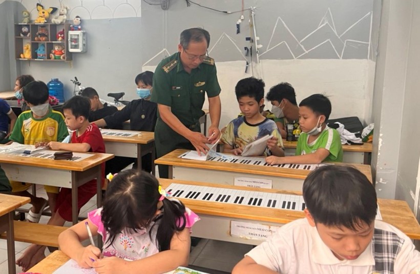 Trung tá Vũ Trường Tính hướng dẫn trẻ tại lớp học tình thương phường Phú Mỹ học bài.