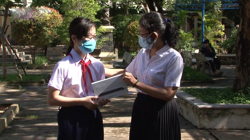 Cô Nguyễn Thị An (bên phải), Hiệu trưởng Trường THCS Huỳnh Thúc Kháng, TP Đà Nẵng, trao máy tính bảng cho học sinh có hoàn cảnh khó khăn.