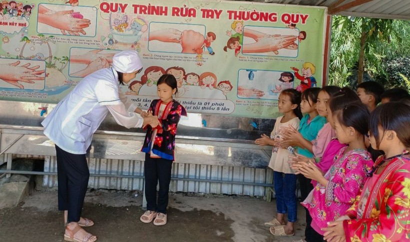 Nhân viên y tế Trường PTDTBT Tiểu học Trung Thu, huyện Tủa Chùa hướng dẫn học sinh rửa tay bằng xà phòng.