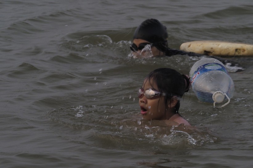 Dù có biển cấm nhưng người dân vẫn đổ về bãi sông Hồng để bơi lội.