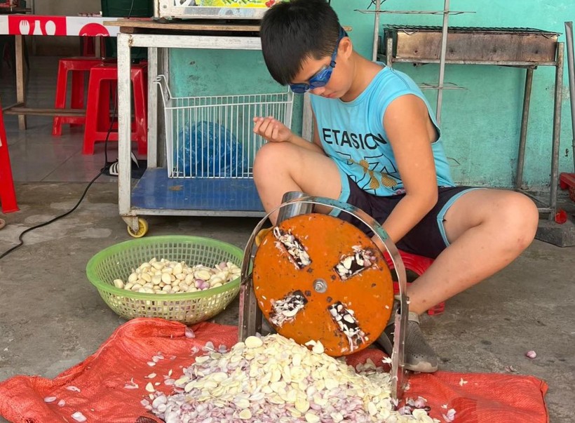 Con trai chị Võ Thị Ngọc ở thị xã Cửa Lò (Nghệ An) giúp mẹ thái tỏi. Ảnh: NVCC
