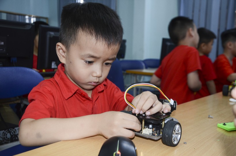 Cậu bé Trần Anh Khôi say sưa tháo lắp robot.