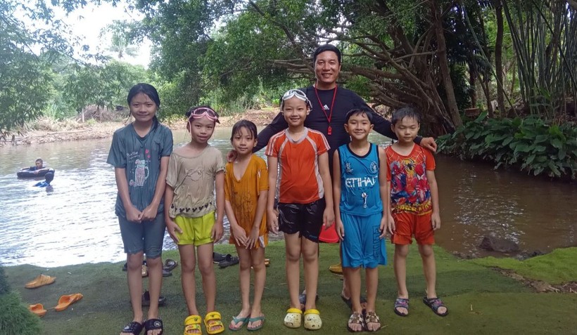 Thầy Hoàng Ngọc Cường với nhóm trẻ tại một lớp học bơi ở suối. Ảnh: NVCC