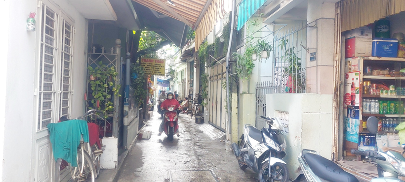 Lối vào Trường Mầm non Cẩm Vân chỉ đủ cho 2 xe máy tránh nhau do có nhiều hàng quán, người dân để xe máy hai bên đường.