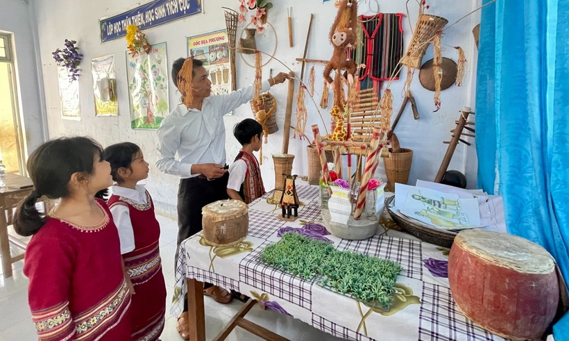 Thầy A Dưnh dạy học sinh tiếng Jrai thông qua đồ dùng, nhạc cụ truyền thống của dân tộc. Ảnh: Trúc Hân