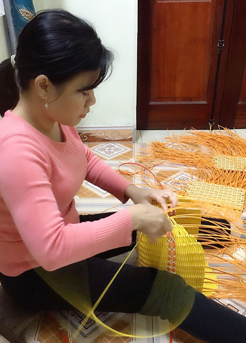 Cô Bùi Thị Hạnh – nhân viên bếp ở huyện Phú Xuyên tranh thủ nhận đồ mây tre đan về nhà làm thêm. Ảnh: NVCC