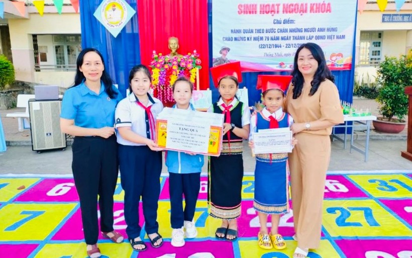 Trường Tiểu học Hoàng Văn Thụ (TP Kon Tum) tặng quà, Bảo hiểm y tế cho học sinh trường khó khăn nhân dịp Tết đến Xuân về. Ảnh: Dung Nguyễn