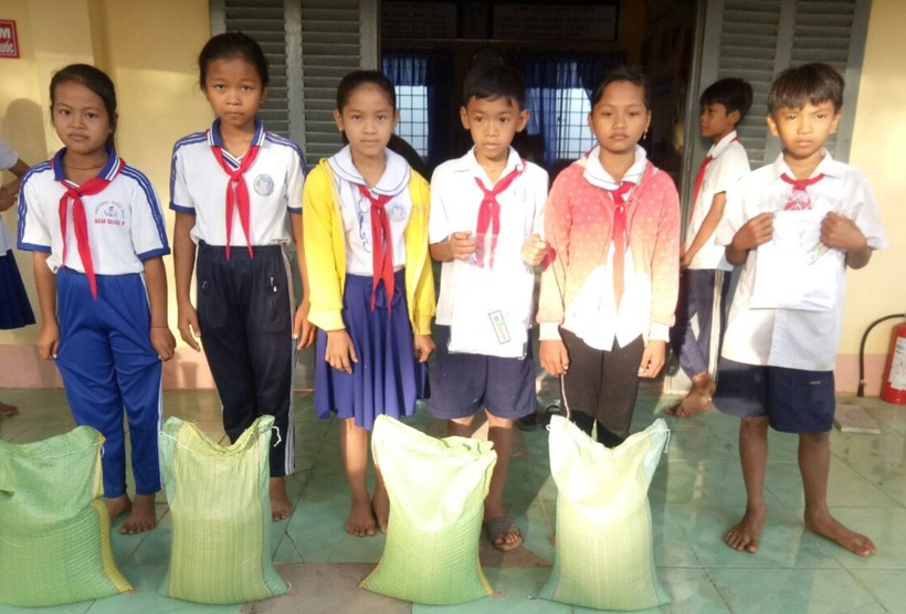 Trao tặng áo và gạo cho học sinh hoàn cảnh khó khăn Trường Tiểu học Hàm Giang B (huyện Trà Cú, Trà Vinh). Ảnh: Q. Ngữ