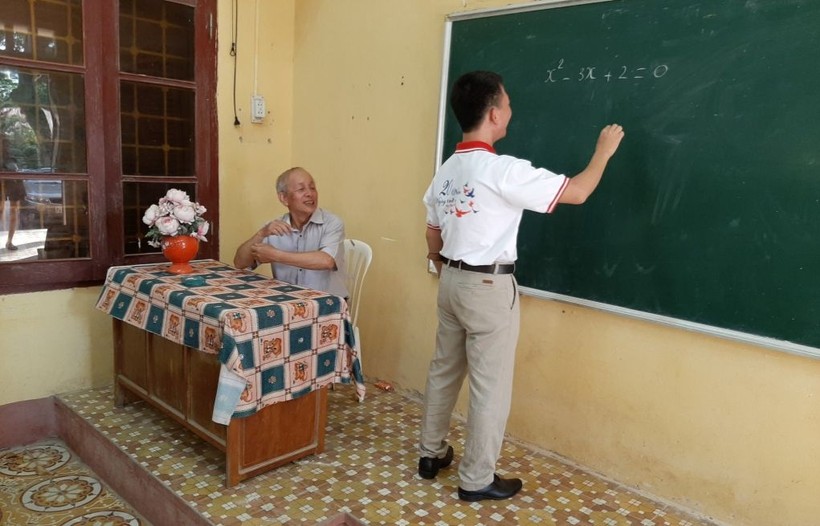 Thầy Nguyễn Trọng Năm (người viết bảng) thăm giáo viên chủ nhiệm cũ. Ảnh NVCC