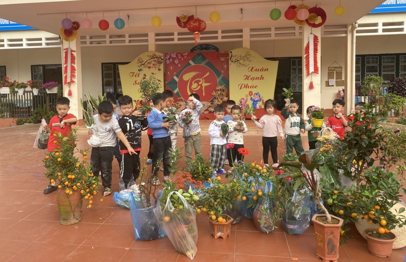 Trẻ Trường Mầm non Hoa Hồng (TP Lào Cai) bên số cây cảnh, cây ăn quả được phụ huynh tặng dịp Tết trồng cây. Ảnh: NTCC