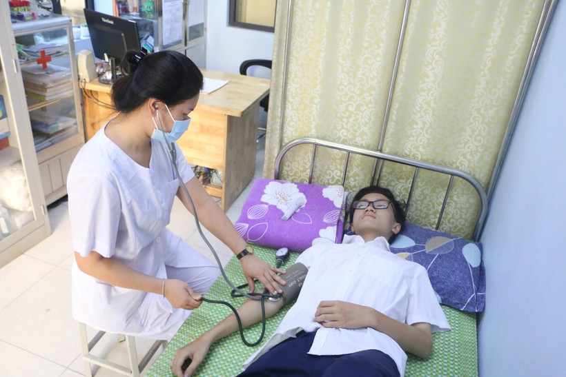 Nhân viên y tế chăm sóc sức khỏe cho học sinh tại Trường THPT Phan Đình Phùng, Hà Nội. Ảnh: TG