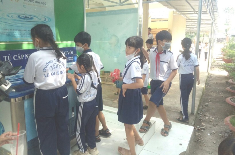 Học sinh Trường Tiểu học Lê Quý Đôn, xã Khánh An (U Minh, Cà Mau) sử dụng hệ thống nước uống sạch. Ảnh: Q. Mến