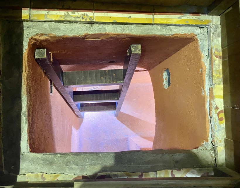 Khi đẩy miếng chắn đáy tủ (nắp hầm) sang bên, một cầu thang hiện ra dẫn lối xuống hầm.