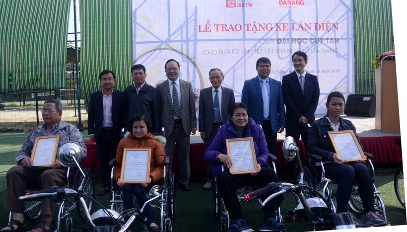 Ban giám hiệu trường ĐH Duy Tân và nhóm nghiên cứu trao tặng xe lăn điện cho người khuyết tật.