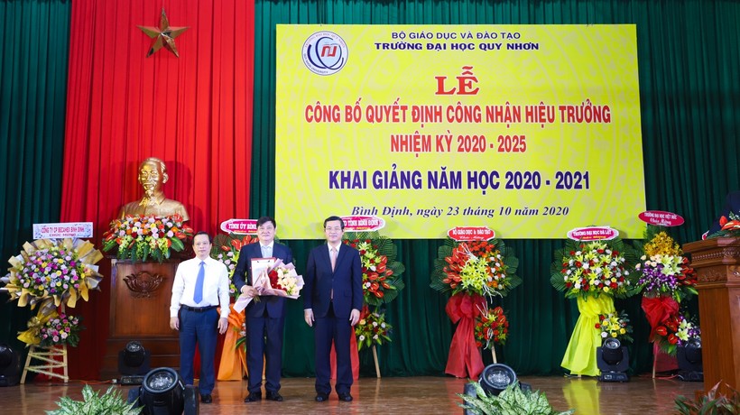 Thứ trưởng Bộ GD&ĐT Nguyển Văn Phúc và Phó chủ tịch UBND tỉnh Bình Định Nguyễn Tuấn Thanh trao quyết định và tặng hoa cho Hiệu trưởng.