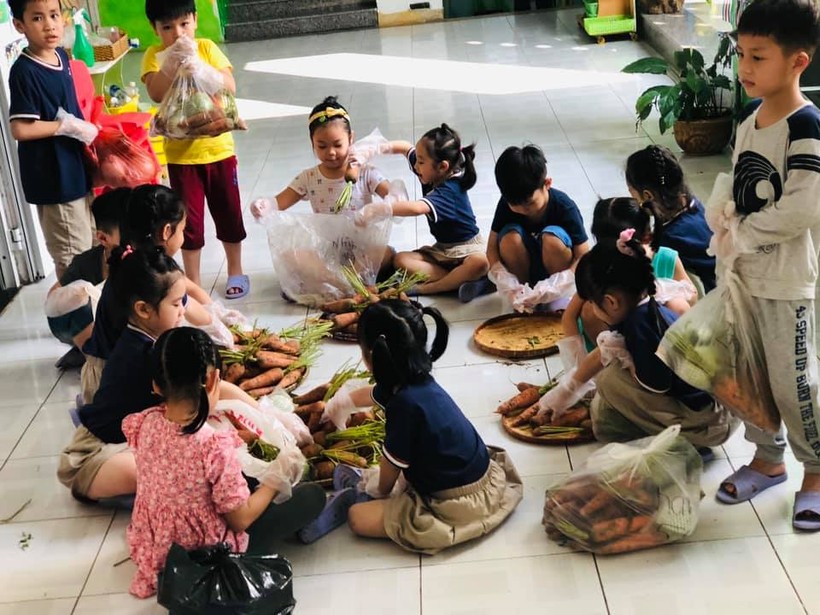 Các bé lớp Lớn trường Mầm non Bình Minh tham gia chia cà rốt vào các túi nhỏ 