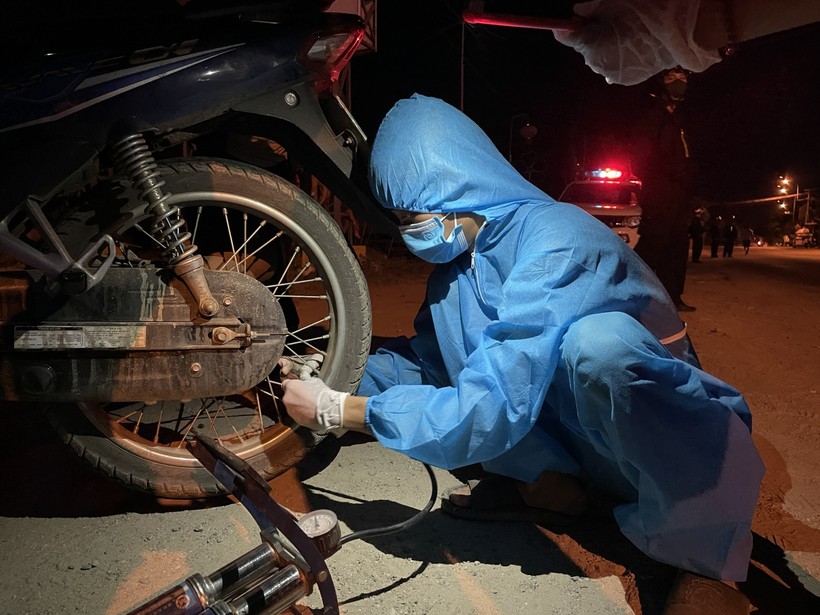 Một chiếc xe máy của người dân trên đường về quê, ngang qua địa phận Đà Nẵng đã được đội SOS ĐH Đông Á hỗ trợ thay săm