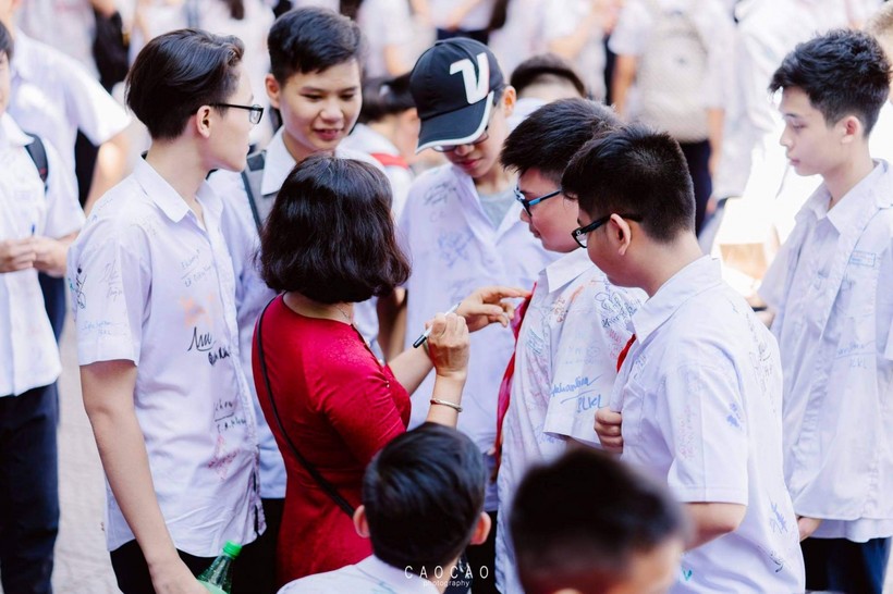 Cô giáo Nguyễn Thị Việt Hà cùng ký lưu niệm với HS lớp 9 trong lễ bế giảng cuối cấp.