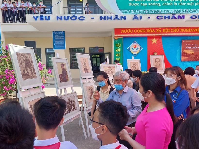 Học sinh Trường THCS Nguyễn Văn Linh (Hòa Vang) nghe họa sĩ - nhà điêu khắc Phạm Hồng - nhân chứng trực tiếp tham gia chiến đấu tại chiến trường khu V kể chuyện tại triển lãm Ký họa chiến trường