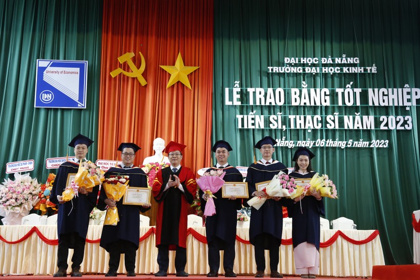 Đại diện Ban giám hiệu Trường ĐH Kinh tế, ĐH Đà Nẵng khen thưởng cho 5 học viên đạt thành tích tốt trong học tập và nghiên cứu. 